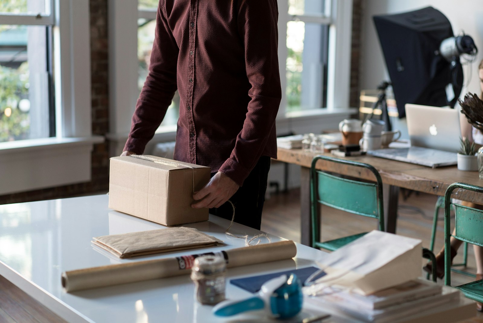 Personne tenant un colis en carton sur une table